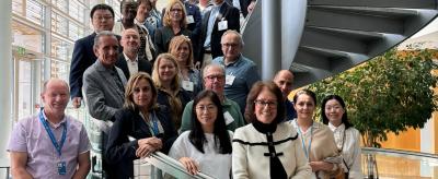 A group of people standing on a spiral staircase in an office environment, posing for a photo.