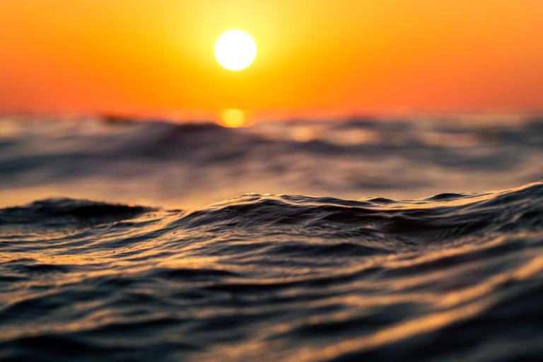 The sun is setting over the ocean.
