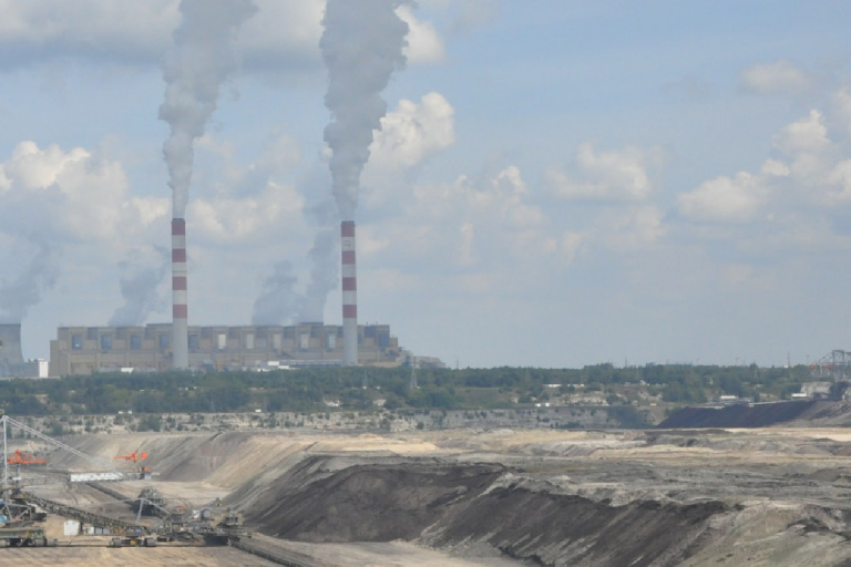An industrial landscape with large power plant chimneys emitting smoke in the background. Text on the image discusses anthropogenic greenhouse gas emissions and related initiatives.
