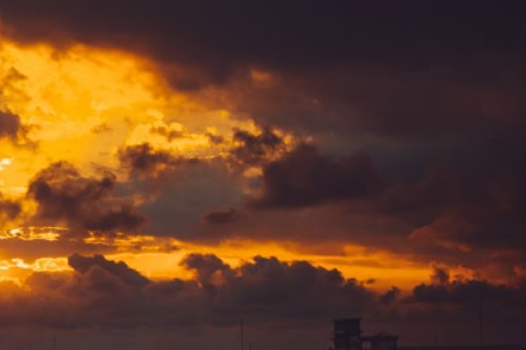 Sunset sky with clouds and a factsheet banner for "Precursors for Aerosols and Ozone" from the Global Climate Observing System.