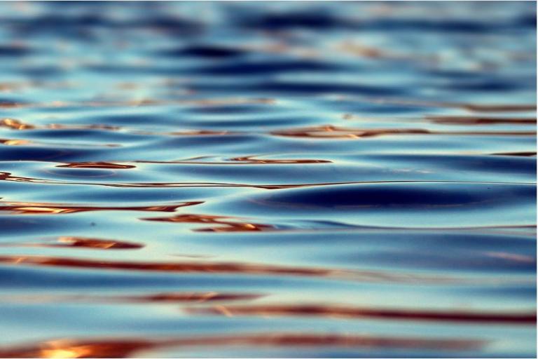 Close-up of rippling water surface with text overlay about Terrestrial Water Storage and climate, featuring logos of WMO, IOC, ISC, and UNEP.