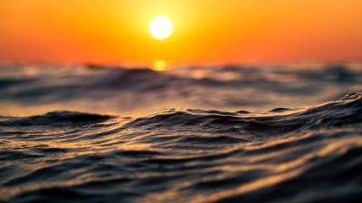 The sun is setting over the ocean.