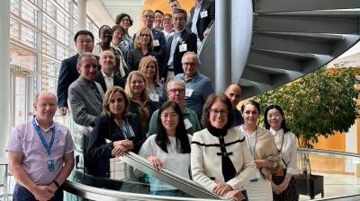 A group of people standing on a spiral staircase in an office environment, posing for a photo.